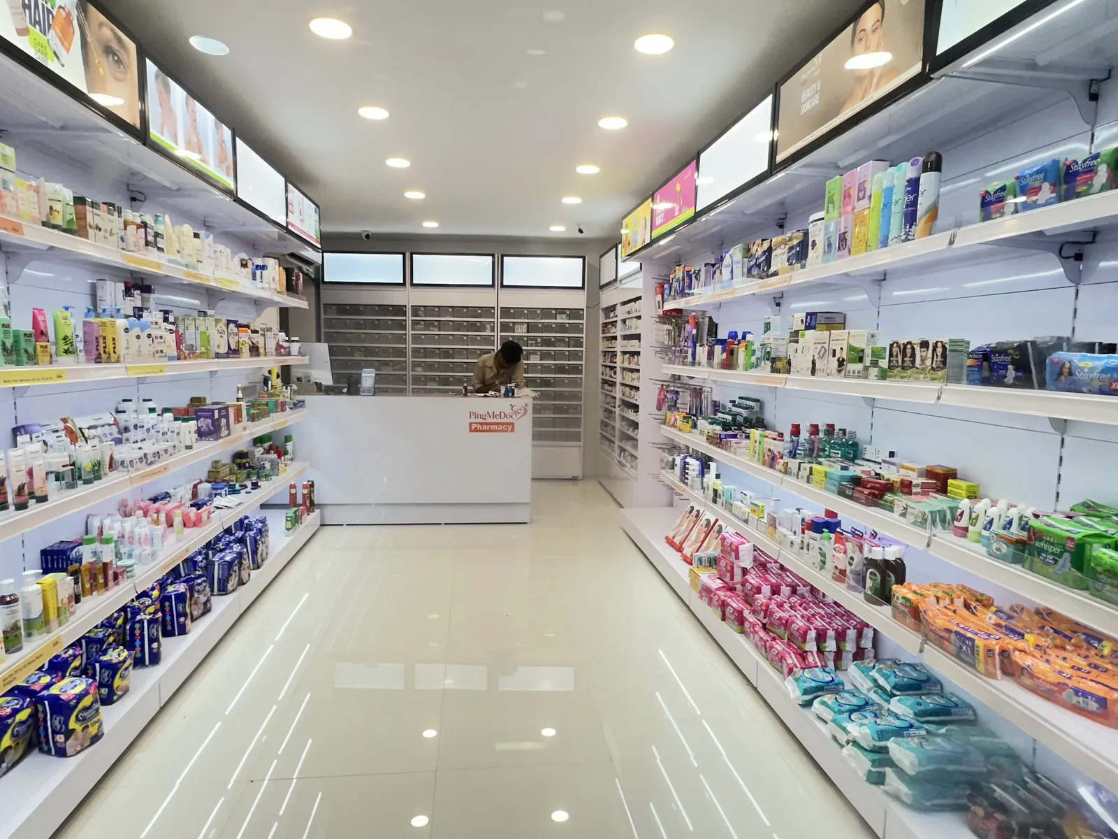 Aisles of medicines and personal-care products inside PMD Pharmacy, Kandigai